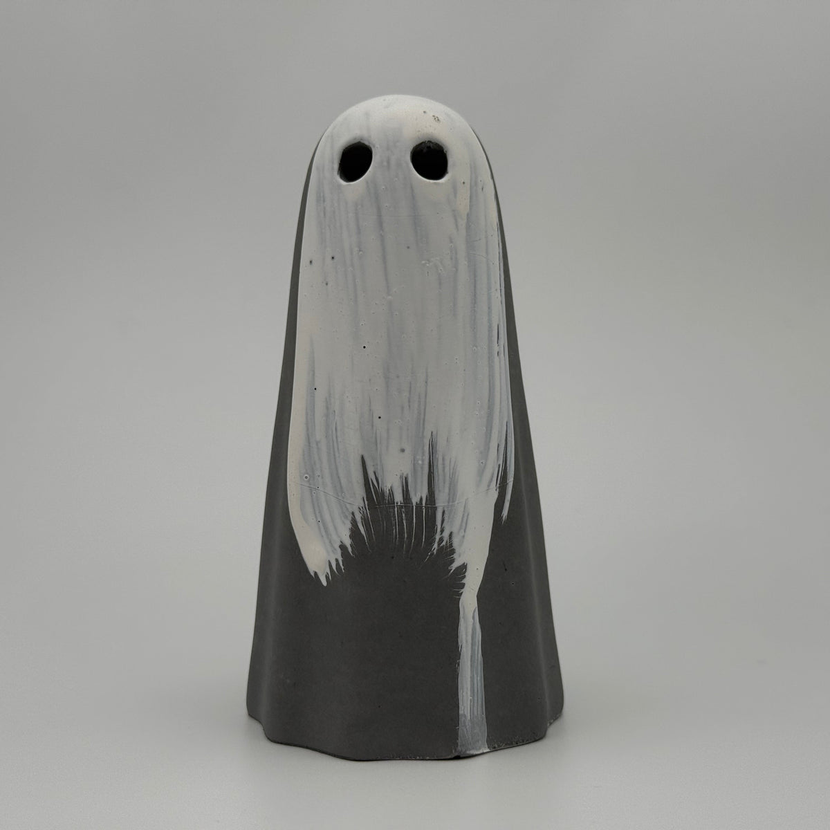 A dark grey ghost figurine with a white painted veil covering her face. Handmade by The Nordic Ghost Merchants.