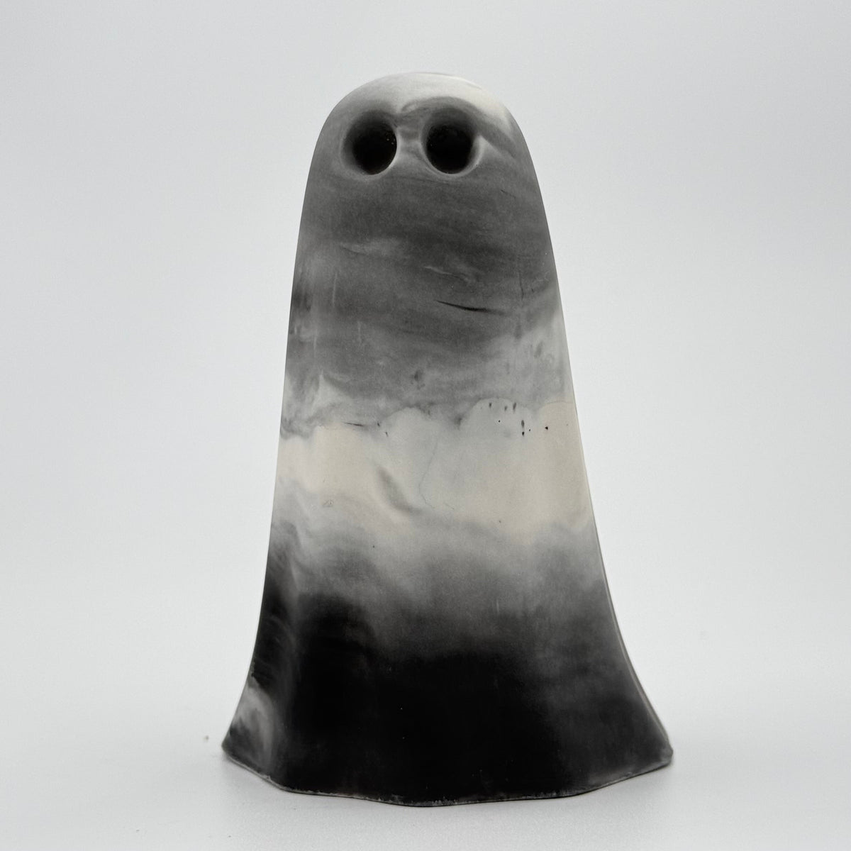 A grey and white smoky coloured ghost figurine made by The Nordic Ghost Merchants. Front view