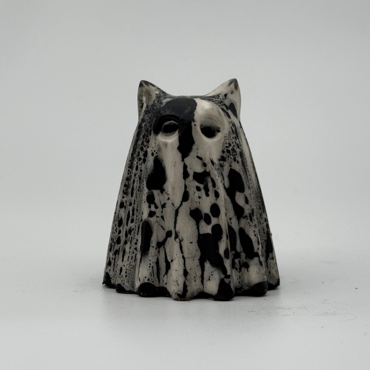 A small white and grey ghost at figurine made by The Nordic Ghost Merchants. Front view