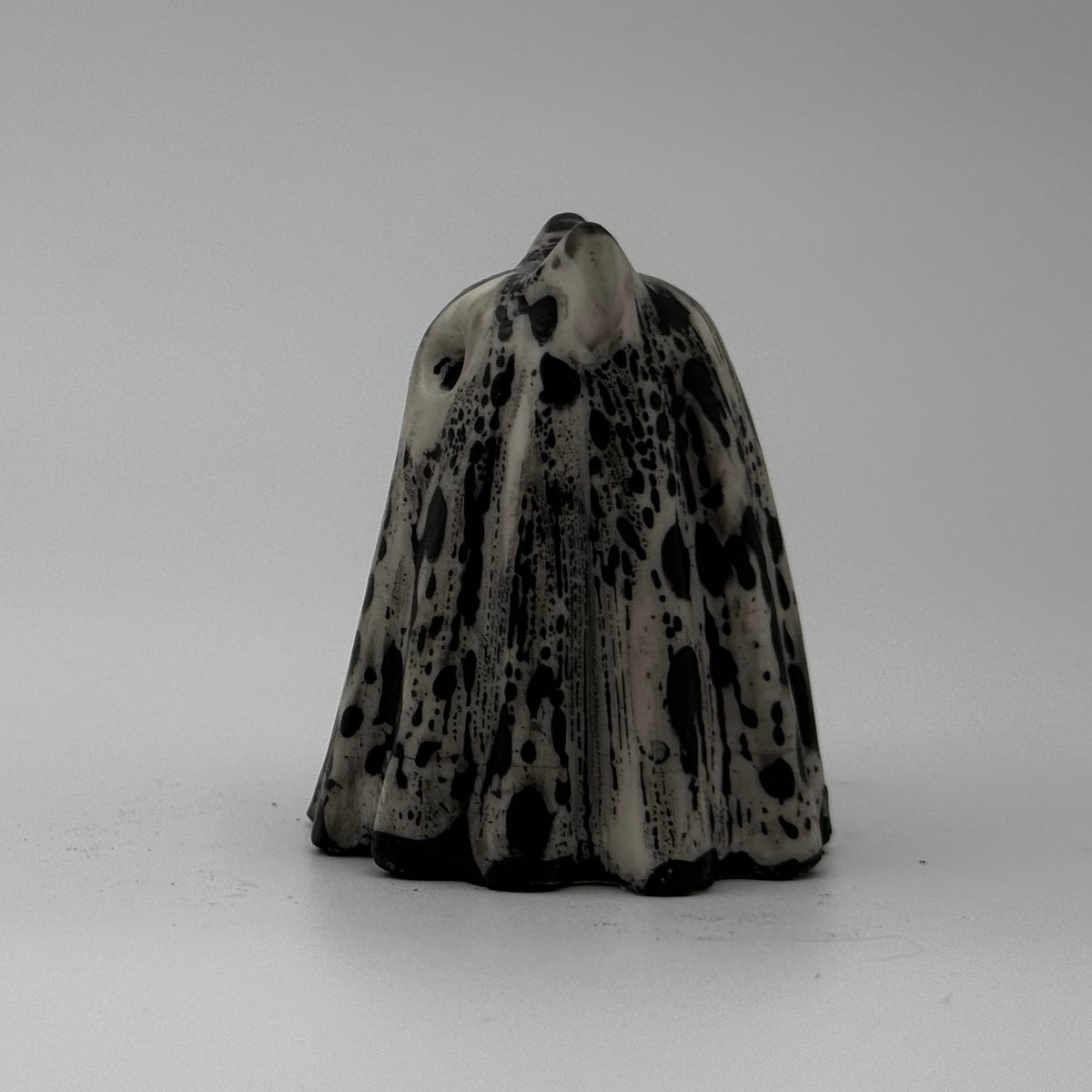 A small white and grey ghost at figurine made by The Nordic Ghost Merchants. Sideview