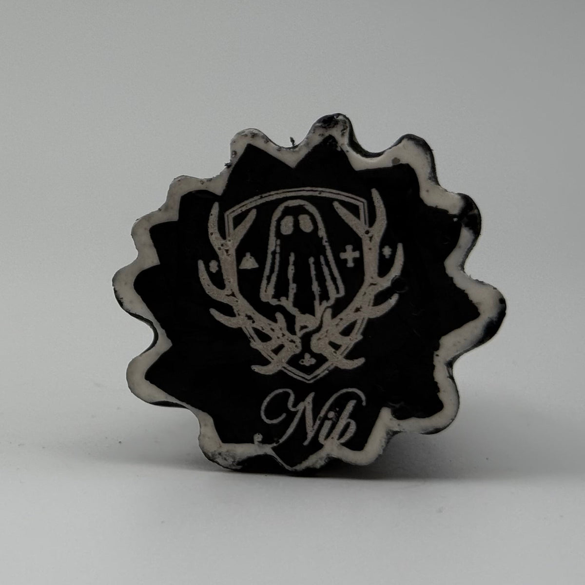 A small black and white ghost cat figurine. The black marks resemble rain dripping down a window. Handmade by The Nordic Ghost Merchants. Base view.