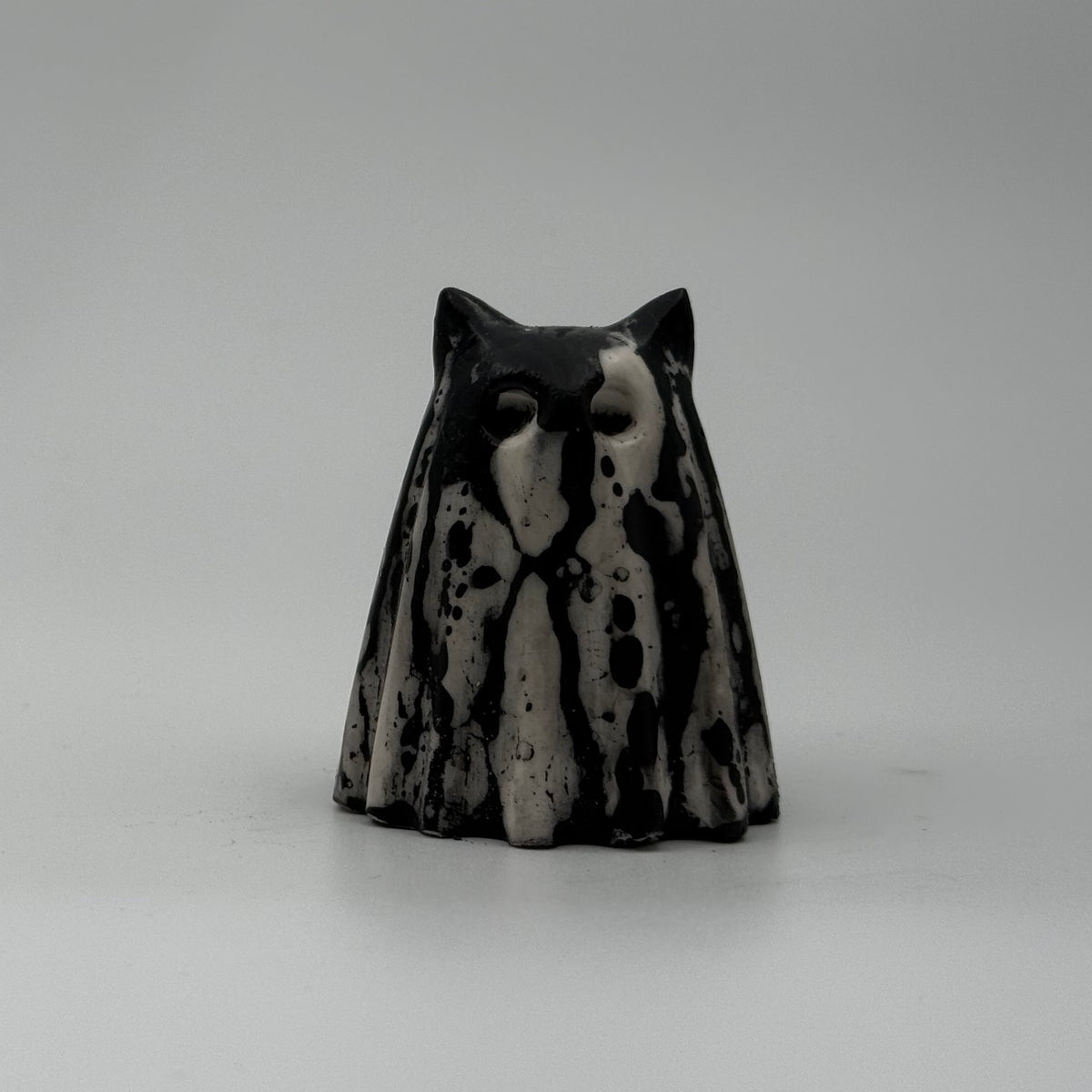 A small white and black coloured ghost cat figurine made by The Nordic Ghost Merchants. Front view
