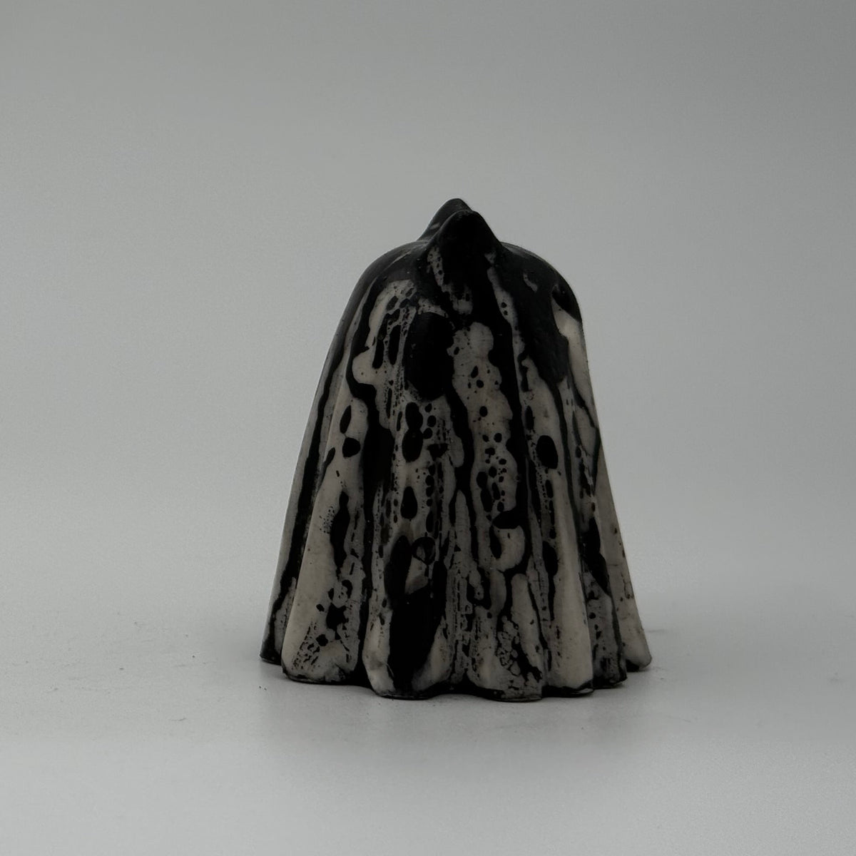 A small white and black coloured ghost cat figurine made by The Nordic Ghost Merchants. Side view