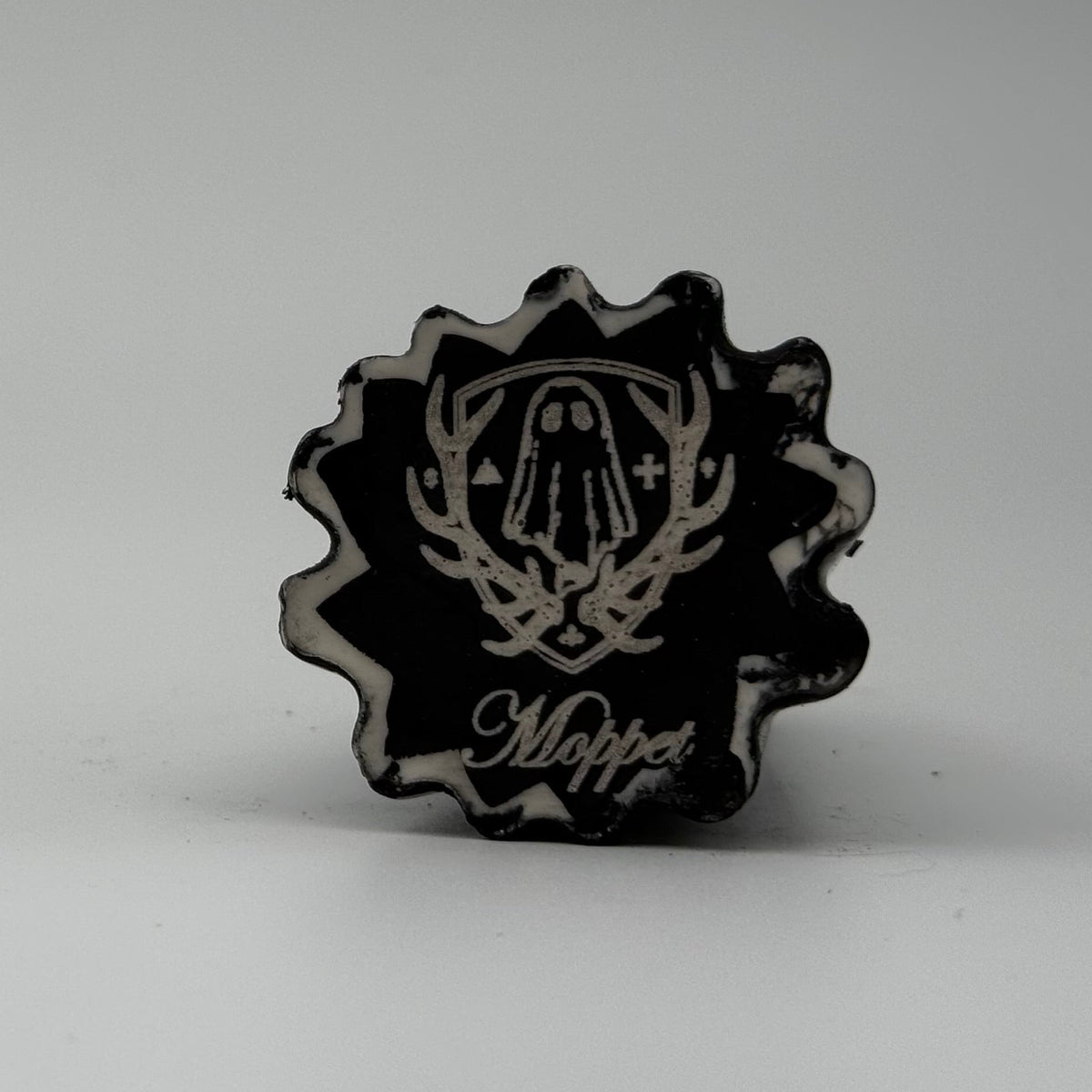 A small black and white ghost cat figurine made by The Nordic Ghost Merchants. The pattern resembles bark. Base view.