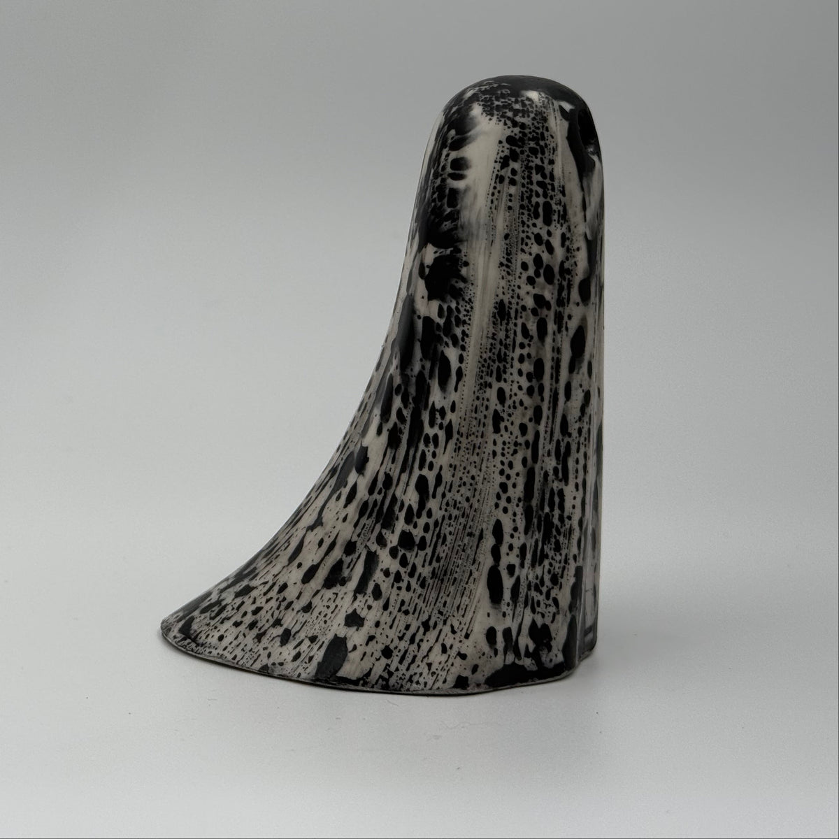 An ivory ghost figurine with black, bark like patterning, made by The Nordic Ghost Merchants. Side view.