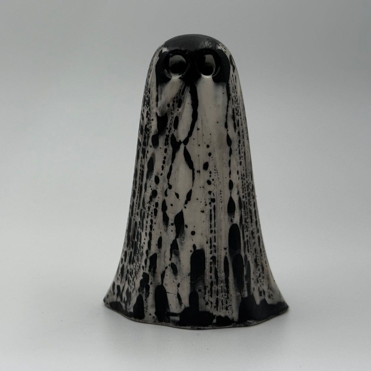 An ivory ghost figurine with black, bark like patterning, made by The Nordic Ghost Merchants. Front view.