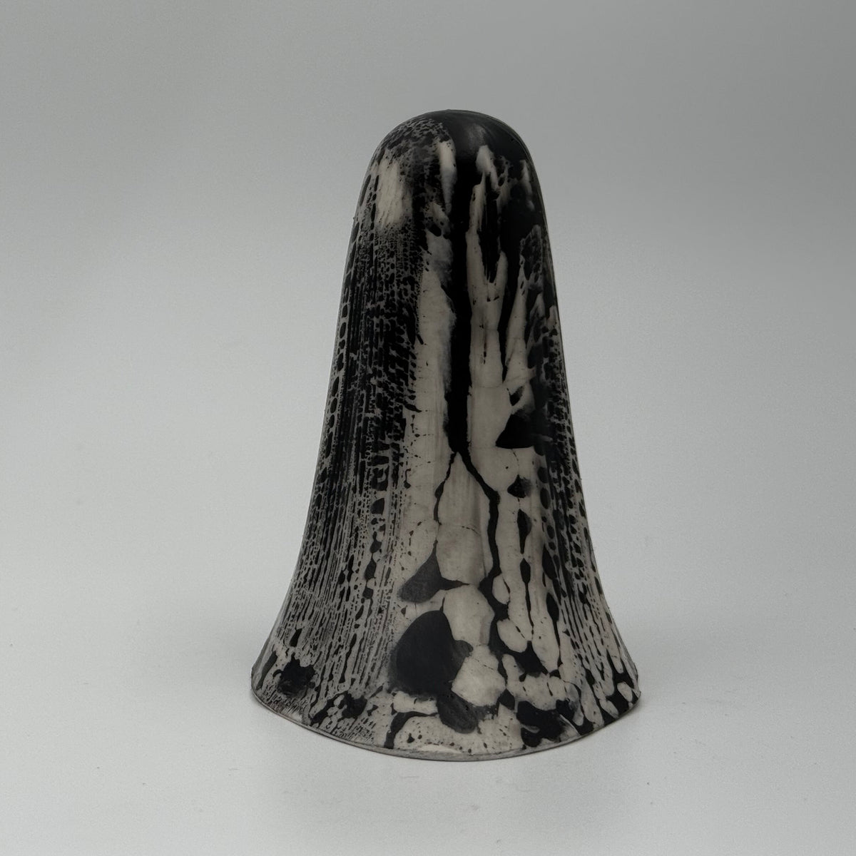 An ivory coloured ghost figurine with black, bark like patterning, made by The Nordic Ghost Merchants. Rear view.