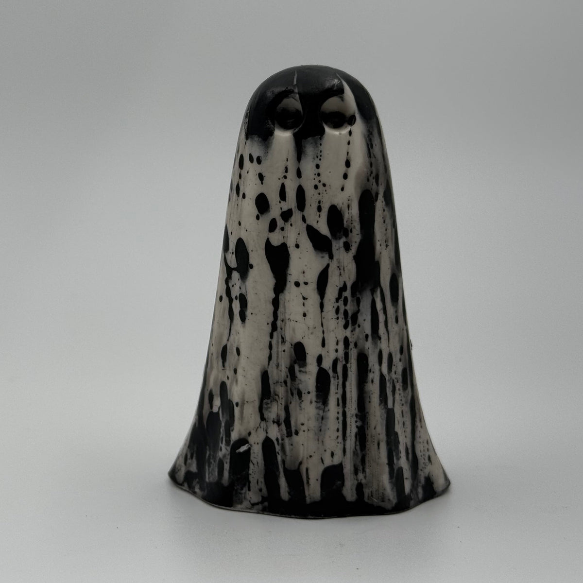 An ivory coloured ghost figurine with dramatic black bark like patterns, made by The Nordic Ghost Merchants. Front view