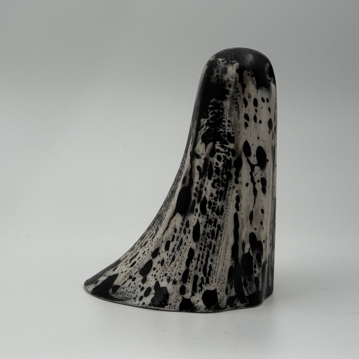 An ivory coloured ghost figurine with dramatic black bark like patterns, made by The Nordic Ghost Merchants. Side view