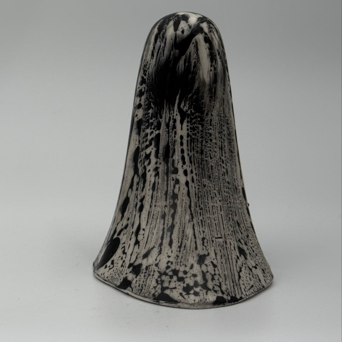 An ivory coloured ghost ornament with dramatic, black, bark like patterning, made by The Nordic Ghost Merchants. Rear view