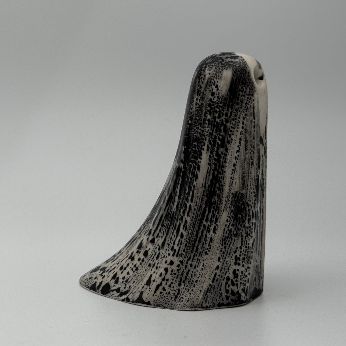 An ivory ghost figurine with black bark like patterning made by The Nordic Ghost Merchants. Front view.