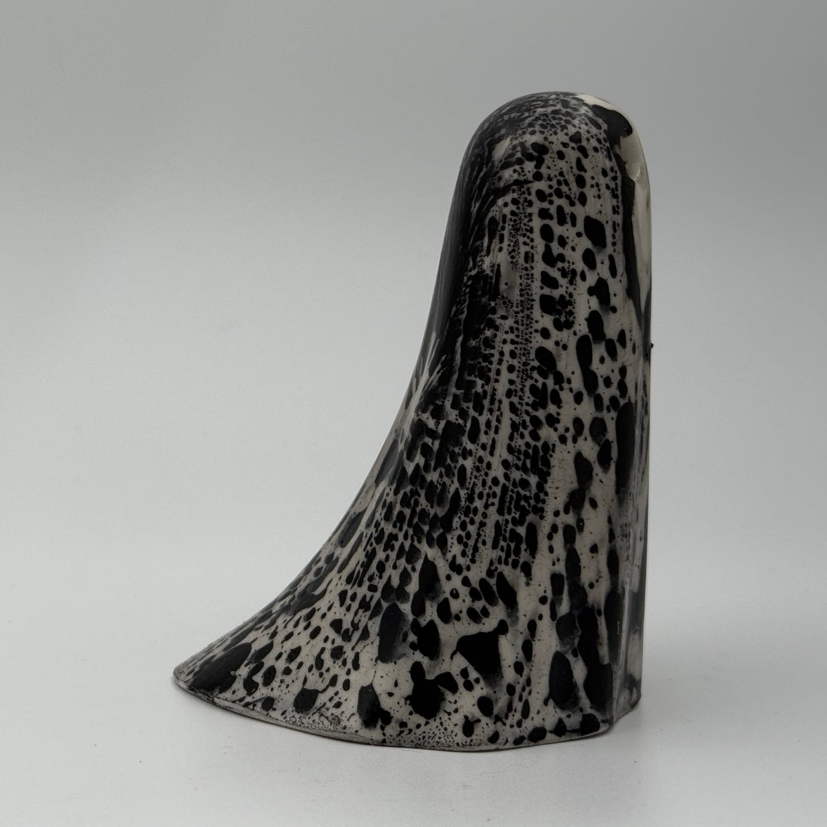 An ivory ghost figurine with black, bark like patterning made by The Nordic Ghost Merchants. Side view
