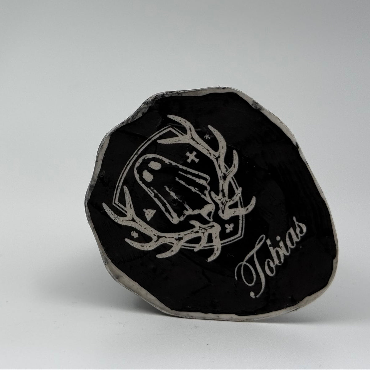 An ivory coloured ghost ornament with dramatic black, bark like patterning, made by The Nordic Ghost Merchants. Base view.