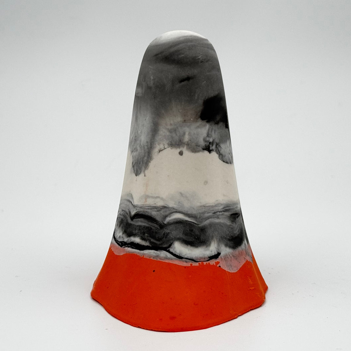 A grey, white and black marbled handmade ghost figurine, made by The Nordic Ghost Merchants. The bottom 1 cm of the ghost is a pumpkin orange colour. Rear view on a grey studio background.