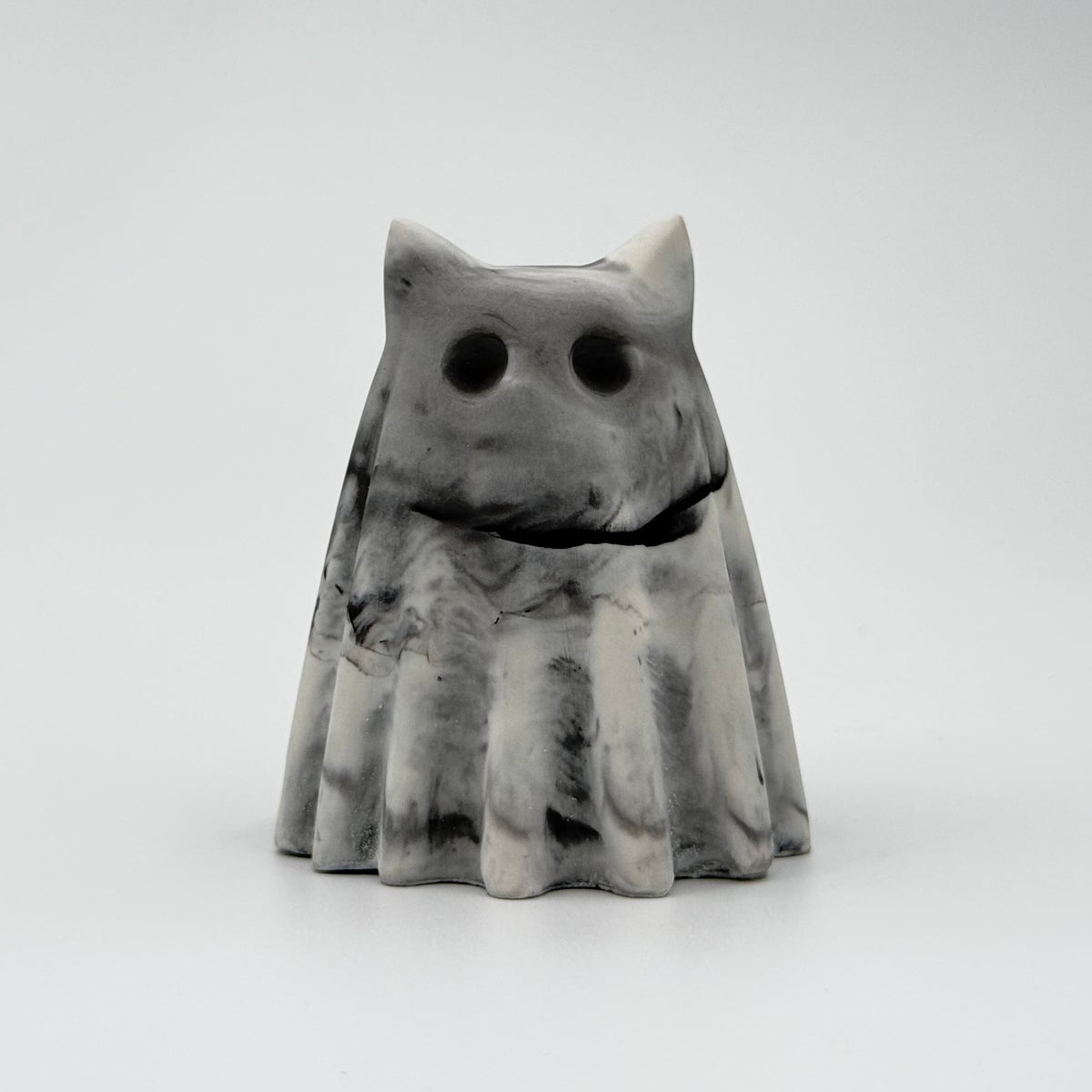 A small grey and white ghost cat figurine, inspired by foggy mornings and made by The Nordic Ghost Merchants. Front view