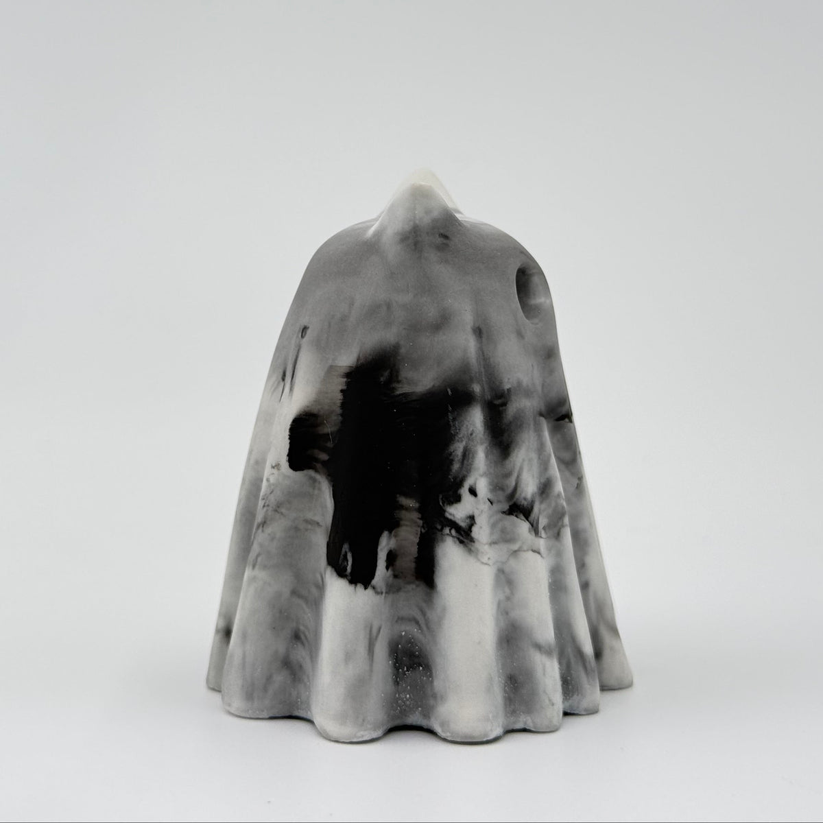 A small grey and white ghost cat figurine, inspired by foggy mornings and made by The Nordic Ghost Merchants. Side view
