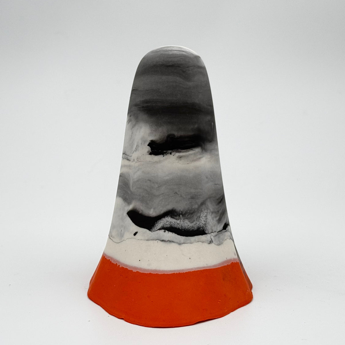 A handmade ghost figurine by The Nordic Ghost Merchants. The head and body of the ghost are a misty or smoky mix of grey and white. The bottom portion is a pumpkin orange shade. Rear view on a grey studio background.