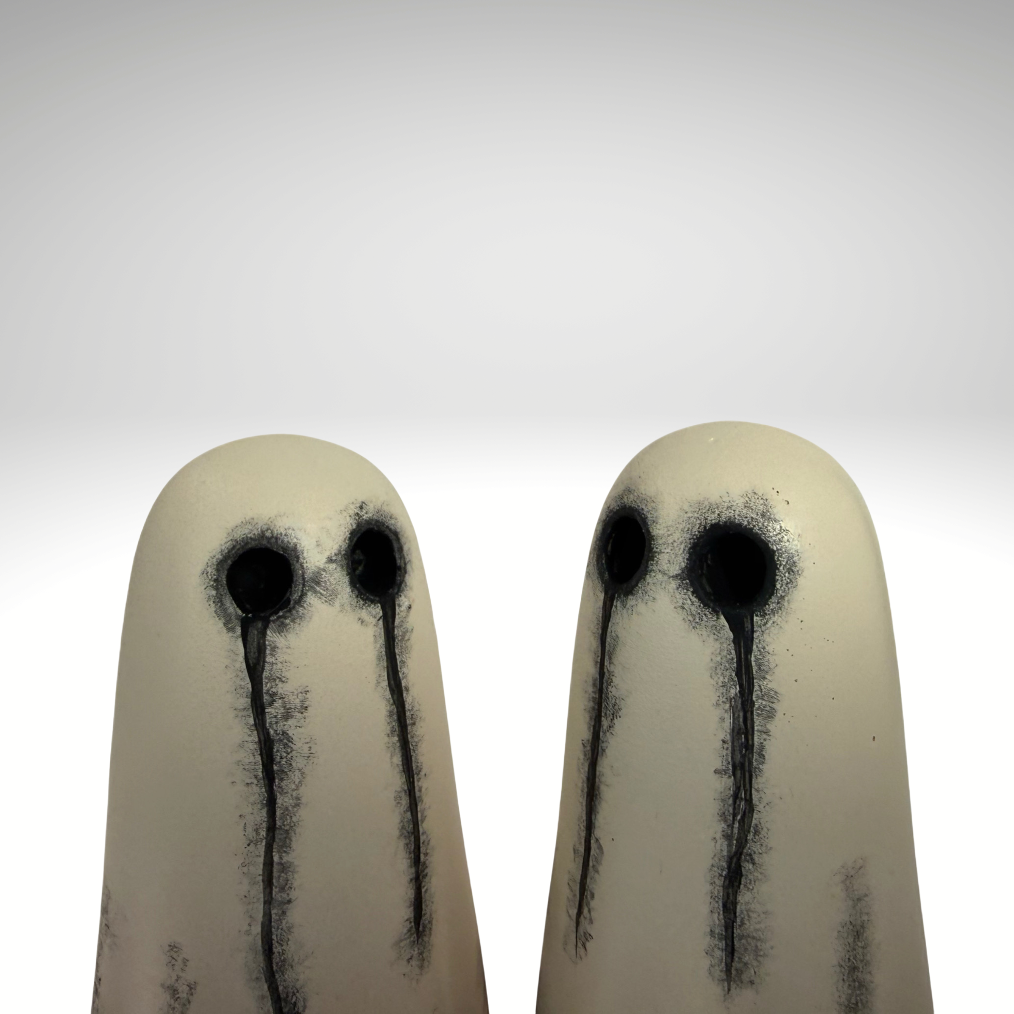 Two small ghost figurines with black teary eyes by The Nordic Ghost Merchants