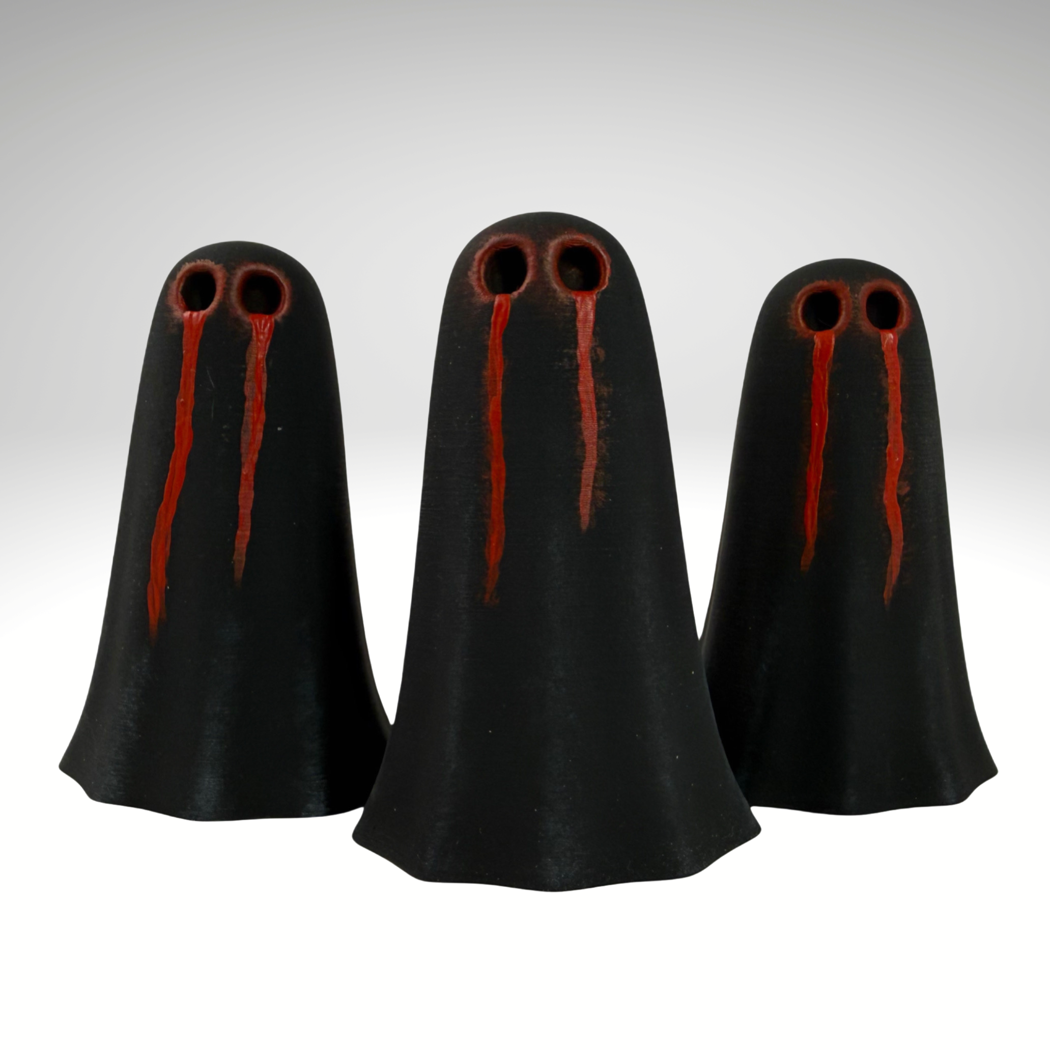 Three black ghost figurines with dark red crying eye details by The Nordic Ghost Merchants