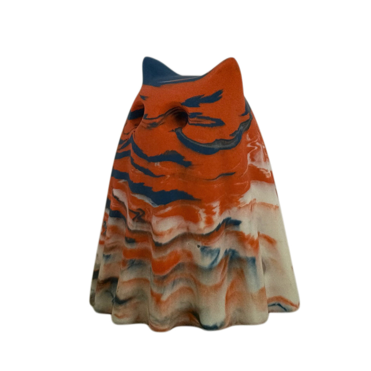 Thornby Windfall Familiar figurine, angled side view showing burnt orange across the face and upper body with deep blue and cream marbling through the folds.
