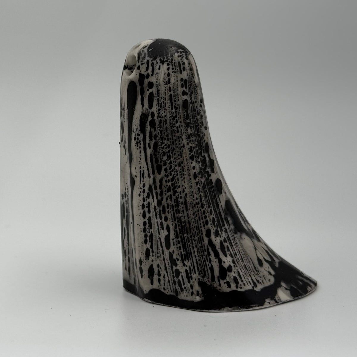 An ivory ghost figurine with black, bark like patterning made by The Nordic Ghost Merchants. Side view