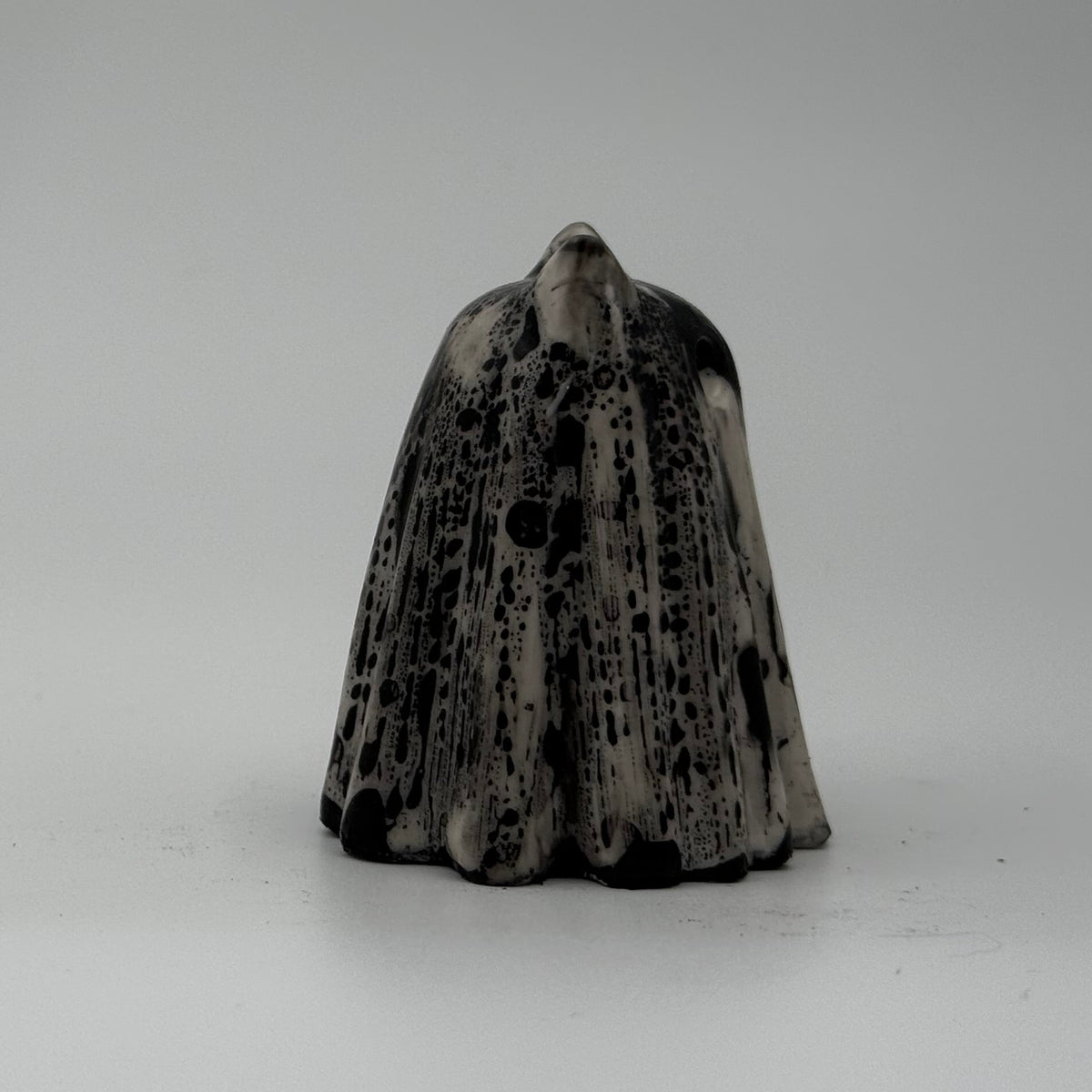 A small white and grey ghost at figurine made by The Nordic Ghost Merchants. Side view