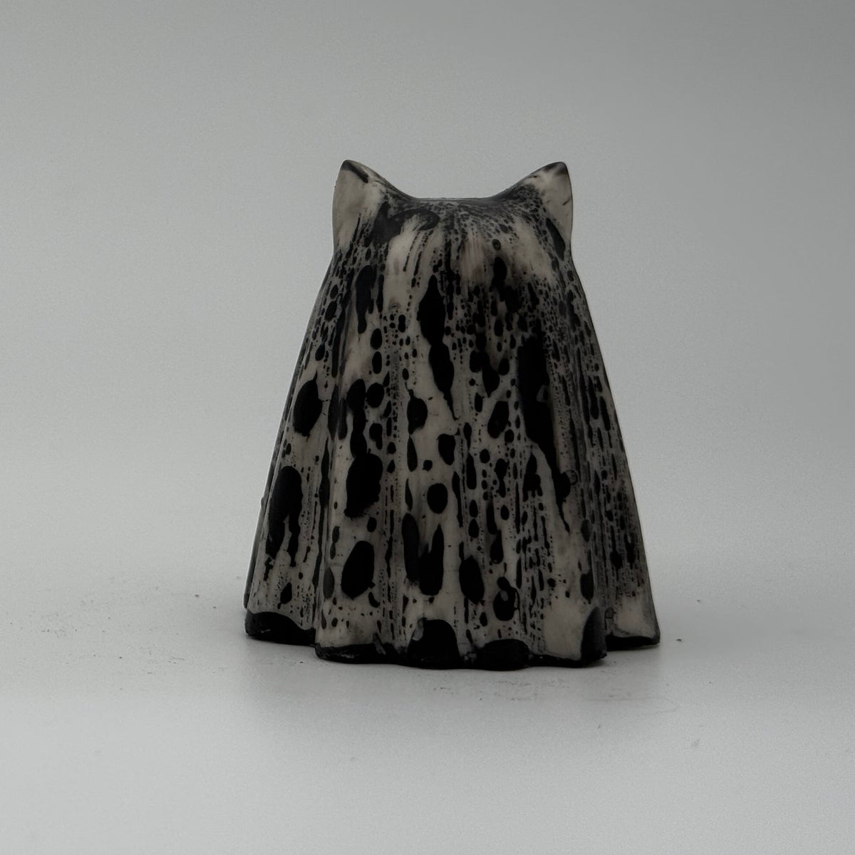A small white and grey ghost at figurine made by The Nordic Ghost Merchants. Rear view