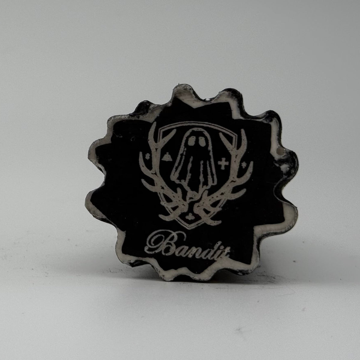 A small black and white ghost cat figurine made by The Nordic Ghost Merchants. Base view.