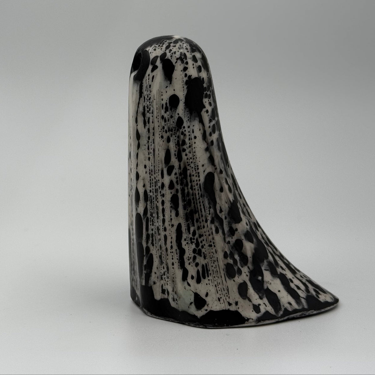 An ivory ghost figurine with black, bark like patterning, made by The Nordic Ghost Merchants. Side view. 
