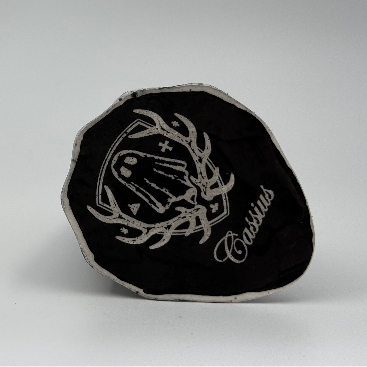 An ivory coloured ghost figurine with black, bark like patterning, made by The Nordic Ghost Merchants. Base view.