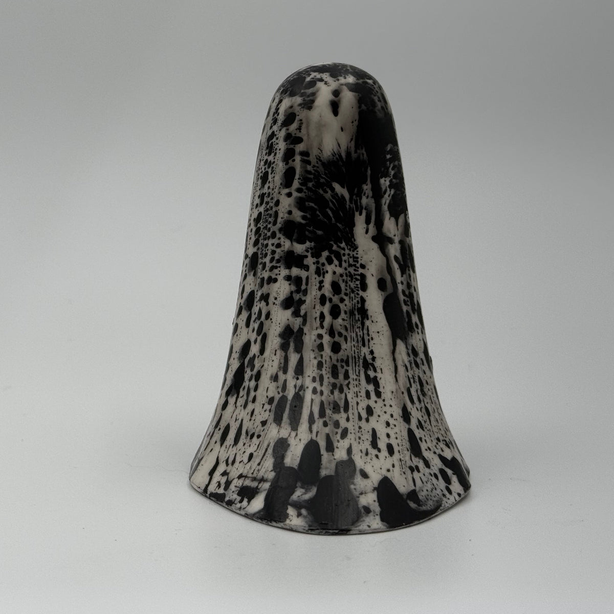 An ivory coloured ghost figurine with dramatic black bark like patterns, made by The Nordic Ghost Merchants. Rear view