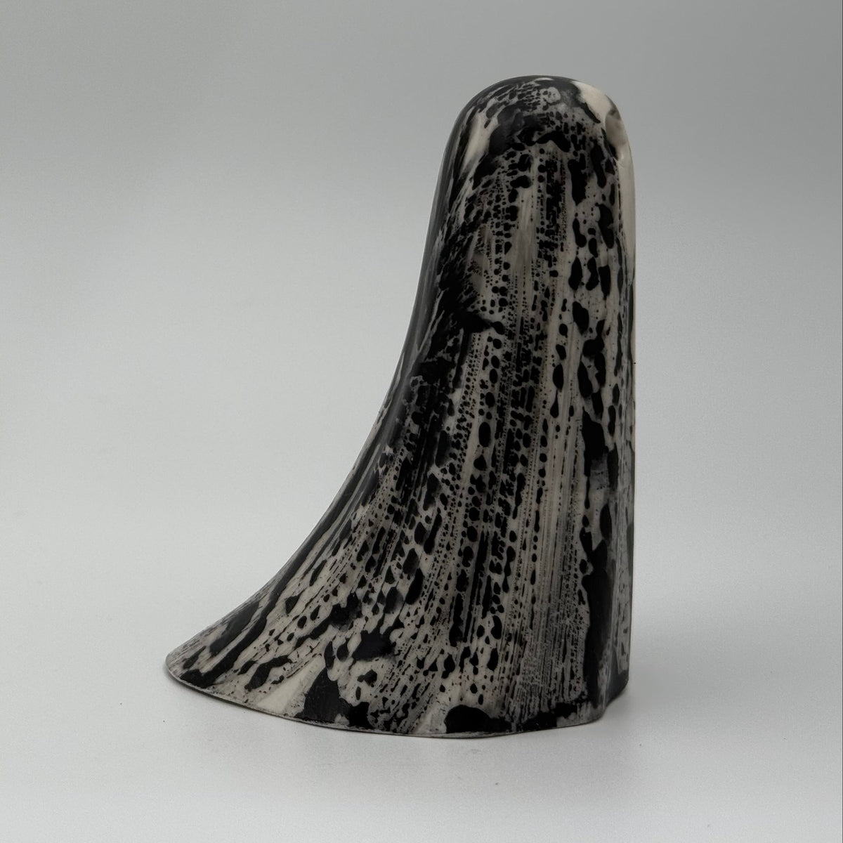 An ivory coloured ghost figurine made by The Nordic Ghost Merchants. The ghost has black, bark like markings.