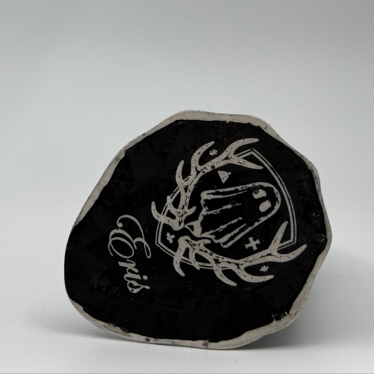 An ivory coloured ghost ornament with dramatic, black, bark like patterning, made by The Nordic Ghost Merchants. Base view