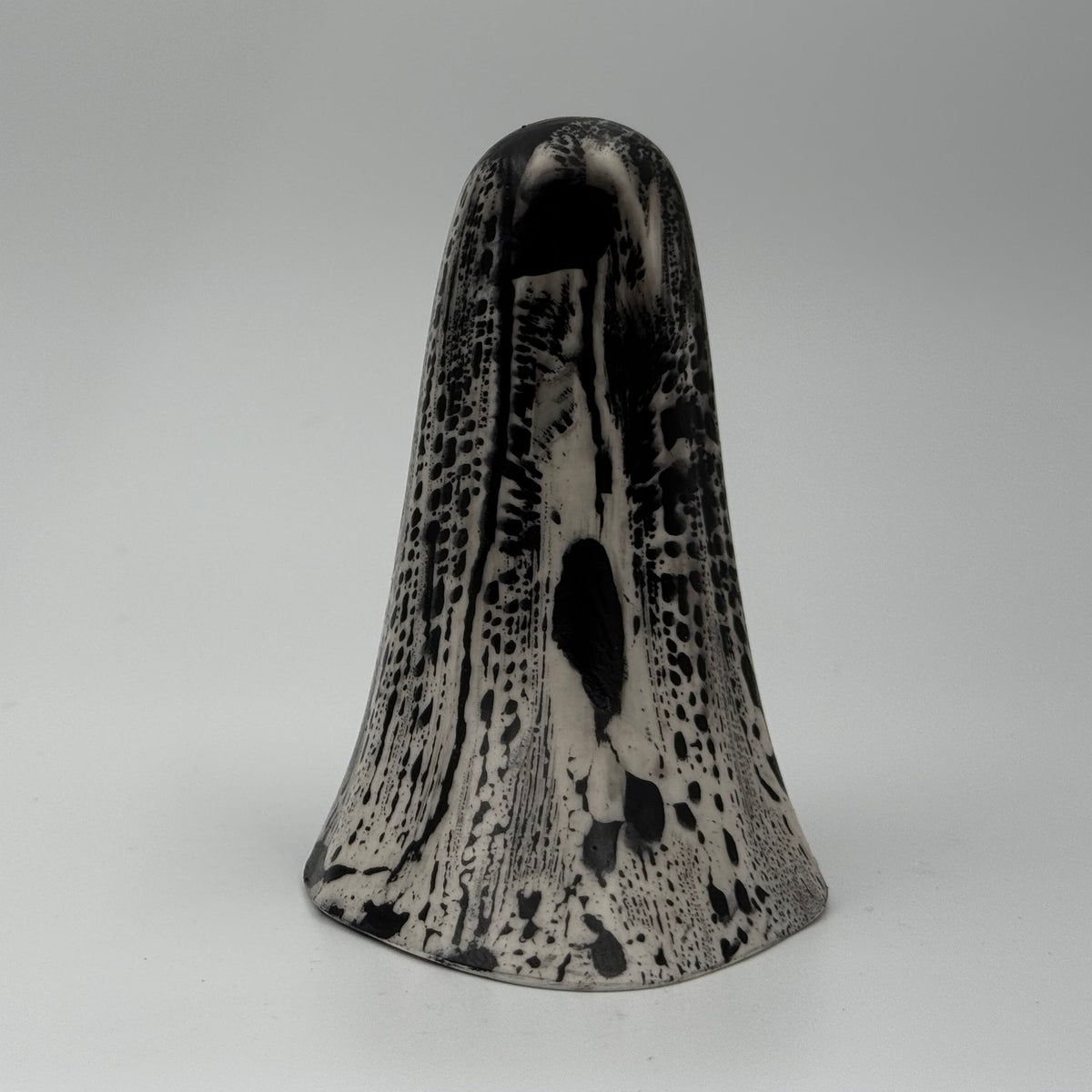 An ivory ghost figurine with dramatic black, bark like patterning, made by The Nordic Ghost Merchants. Rear view.