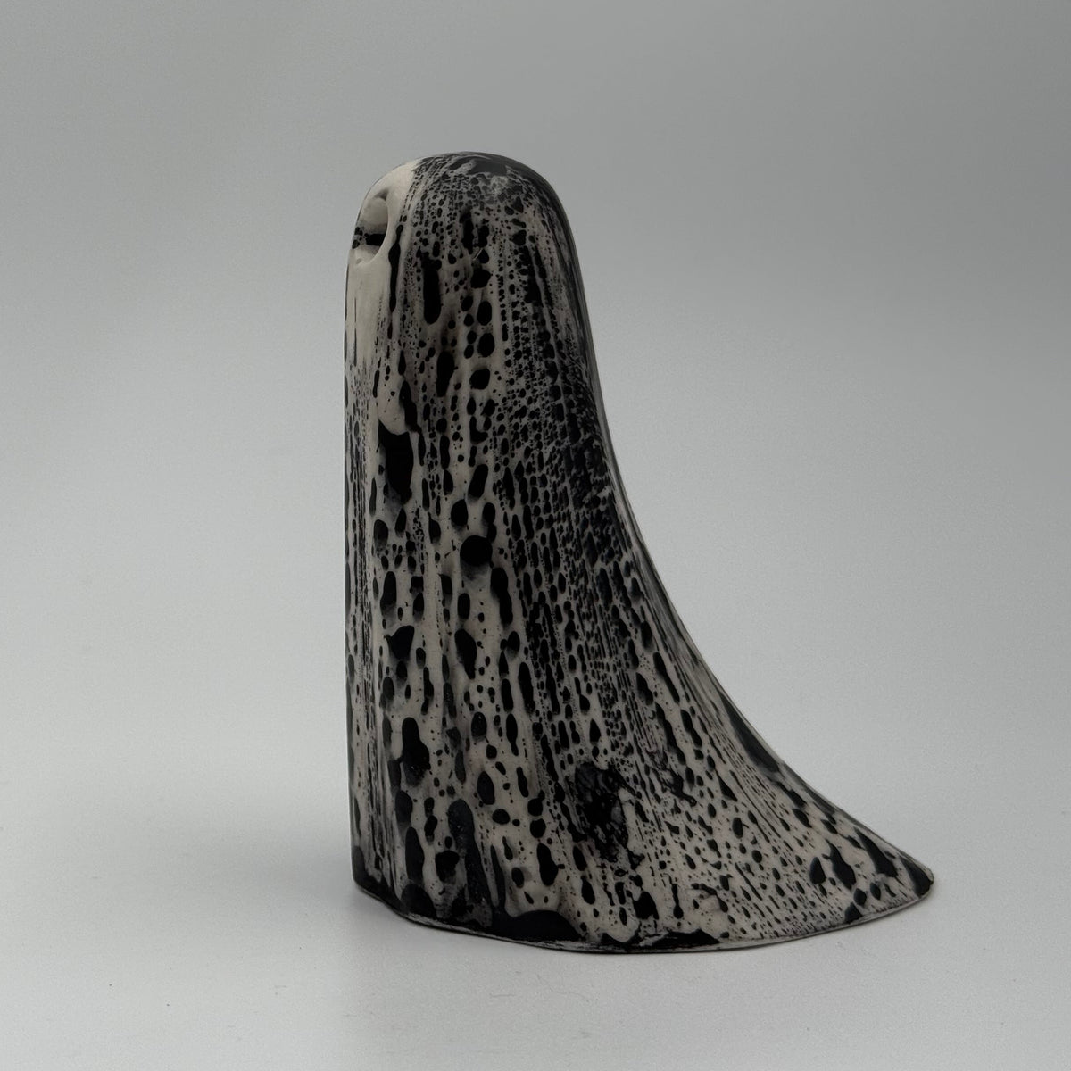 An ivory ghost figurine with black bark like patterning made by The Nordic Ghost Merchants. Side view.