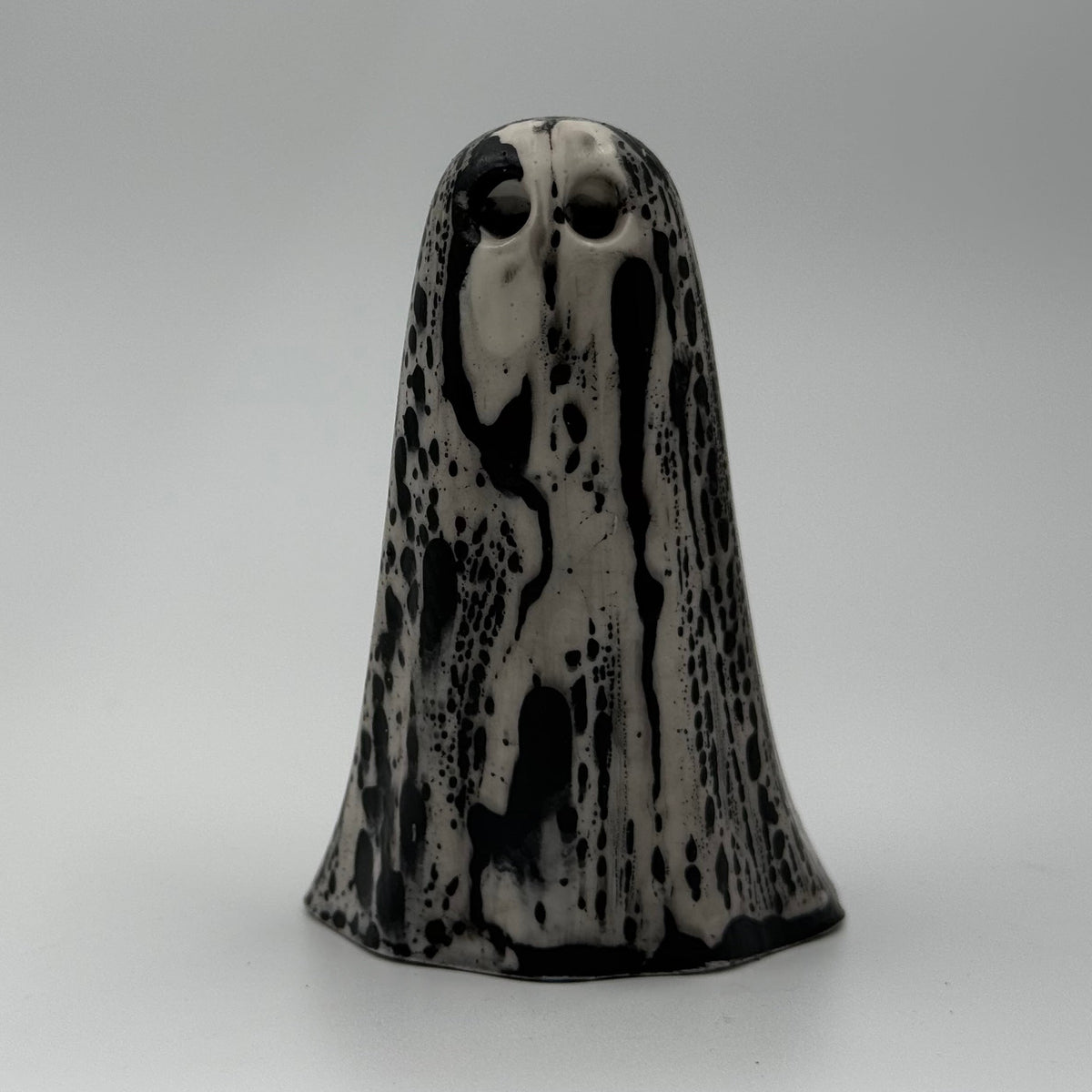 An ivory ghost figurine with black, bark like patterning made by The Nordic Ghost Merchants. Front view