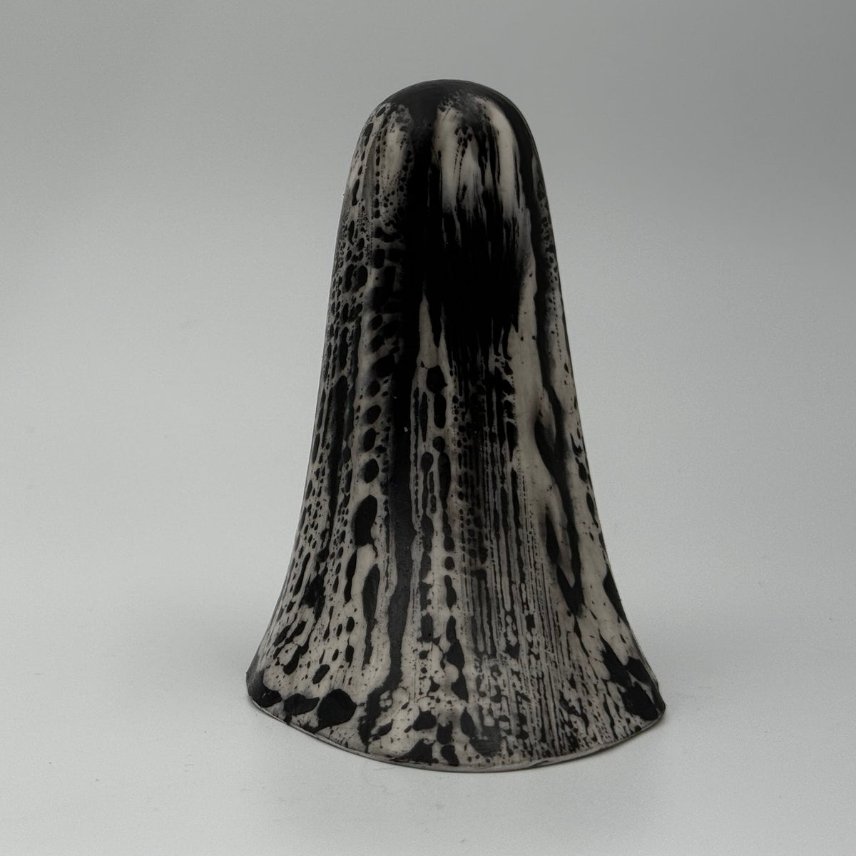 An ivory coloured ghost ornament with dramatic black, bark like patterning, made by The Nordic Ghost Merchants. Rear view.