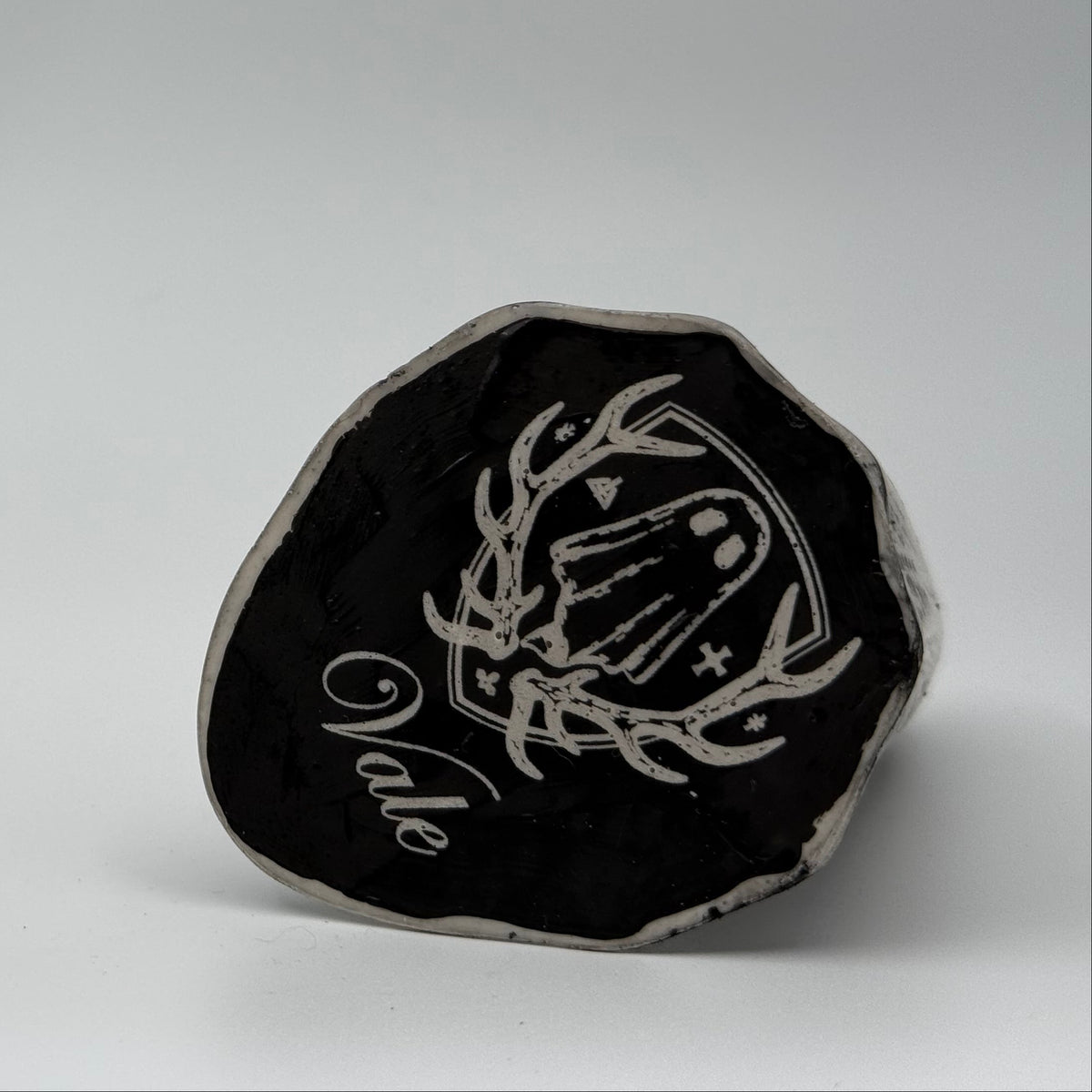 An ivory coloured ghost ornament with dramatic, black bark like patterning, made by The Nordic Ghost Merchants. Base view.