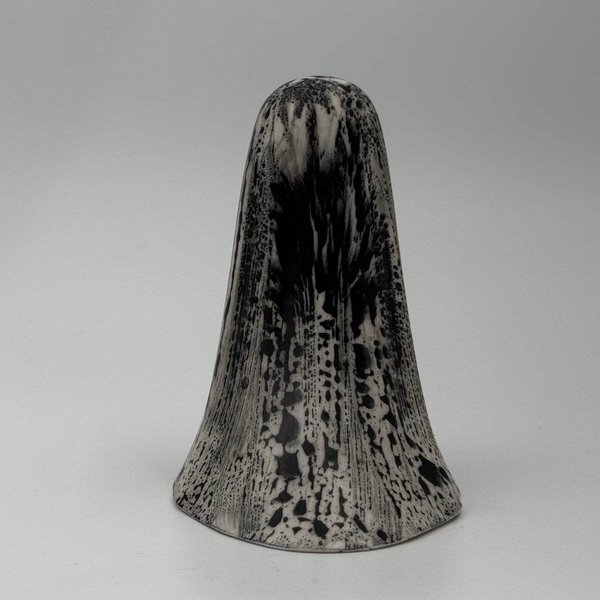 An ivory ghost ornament with dramatic black, bark like patterning, made by The Nordic Ghost Merchants. Rear view