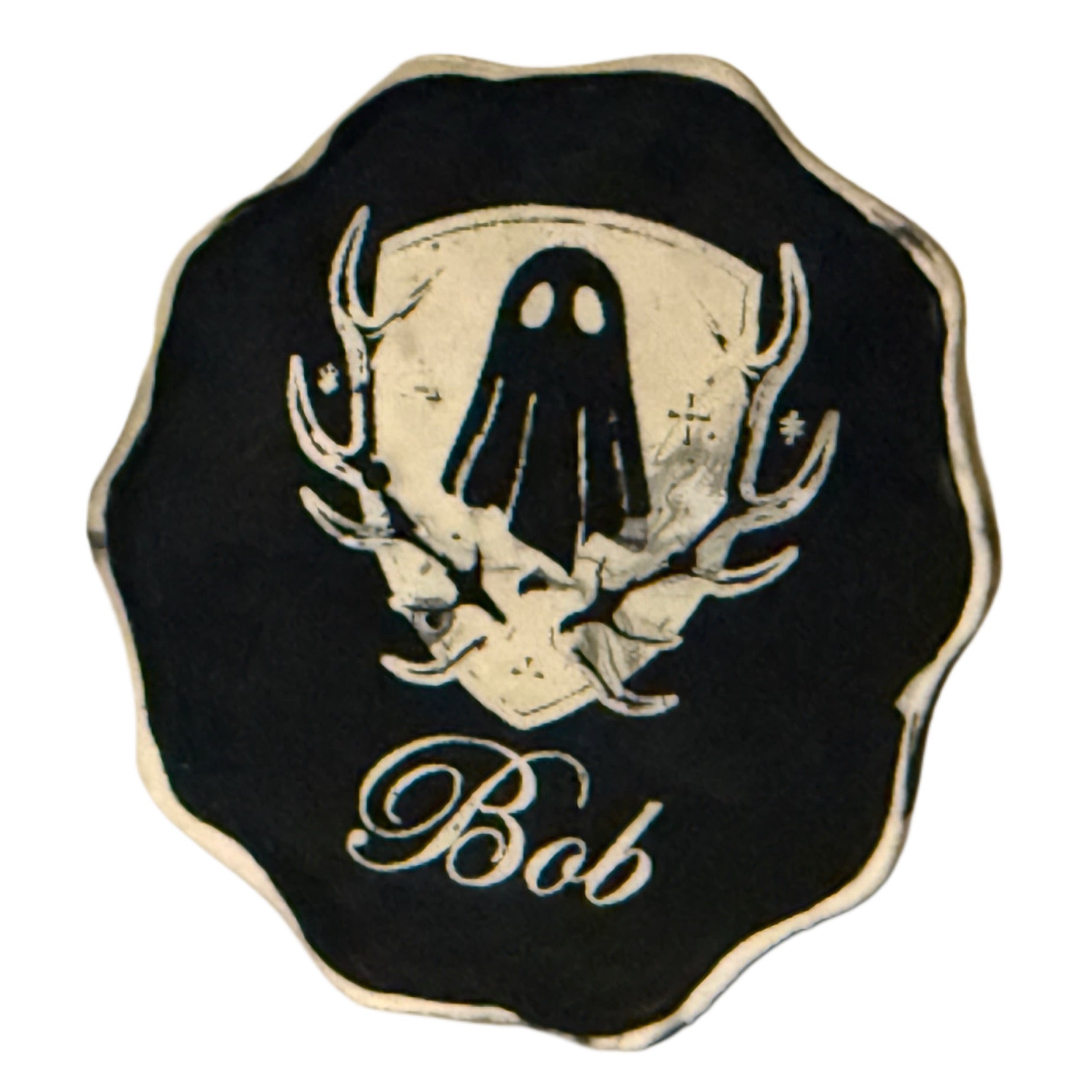 The base of a ghost figurine by The Nordic Ghost Merchants, engraved with their logo and the ghost's name.