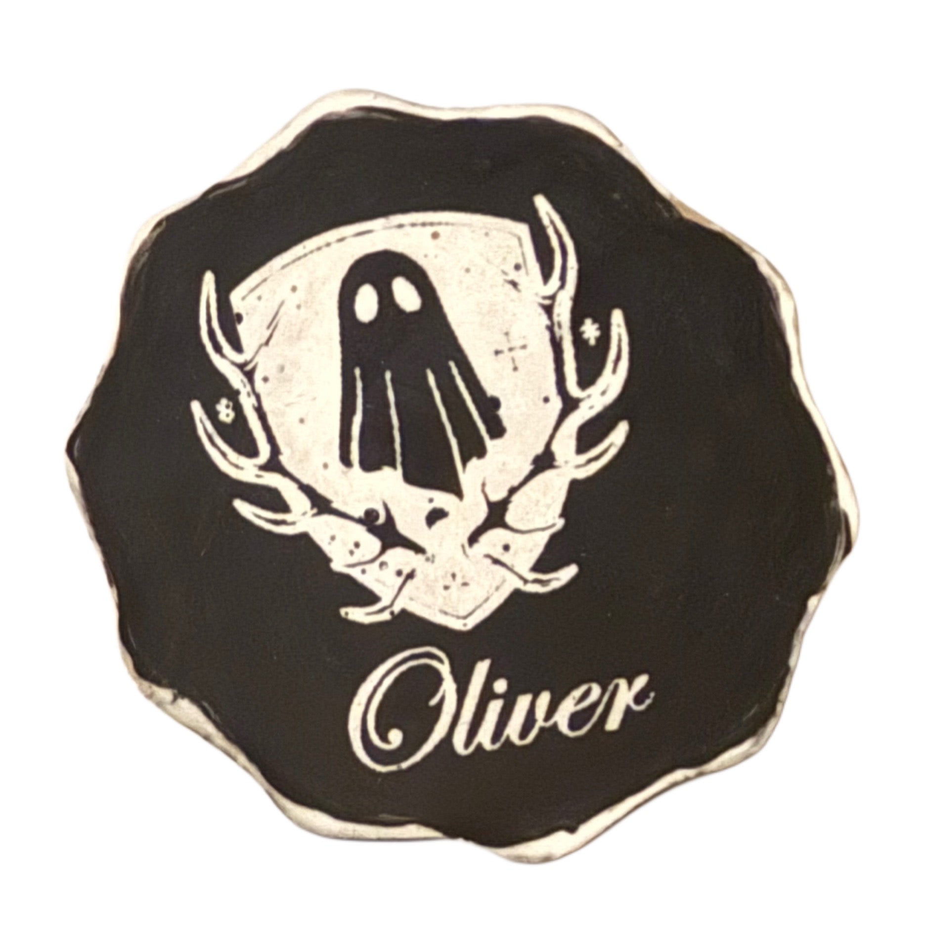 The base of a ghost figurine by The Nordic Ghost Merchants, engraved with their logo and the ghost's name.