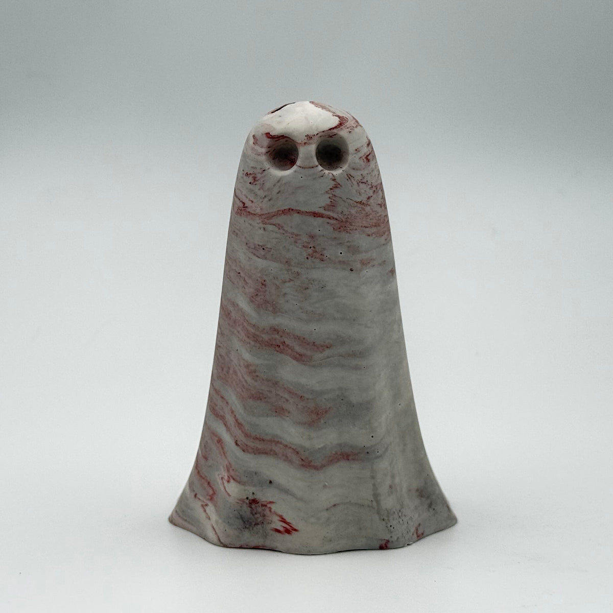 A small grey and white marbled ghost figurine made by The Nordic Ghost Merchants. Dark red ripples run across the ghost. Front view on a neutral grey studio background.