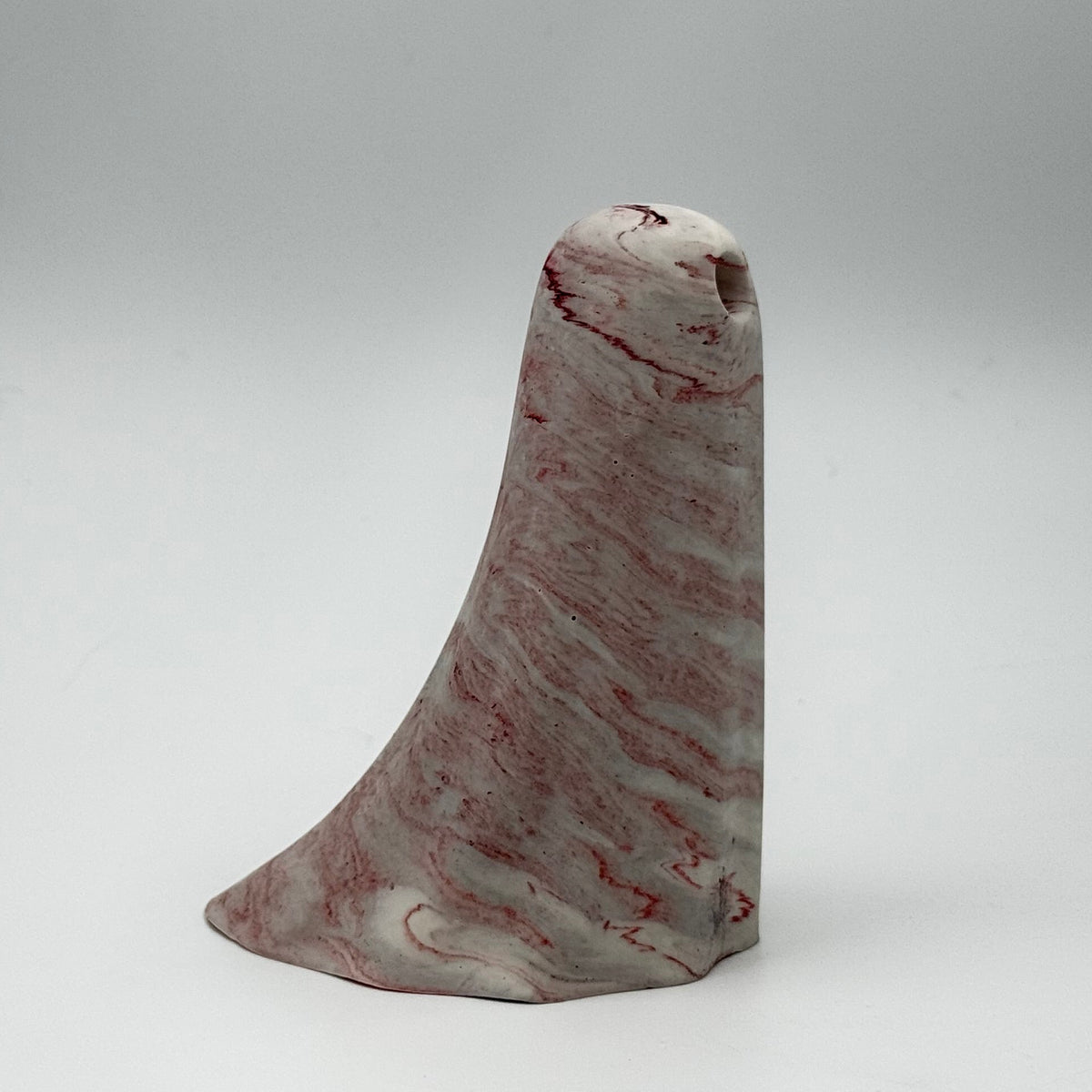 A small grey and white marbled ghost figurine made by The Nordic Ghost Merchants. Dark red ripples run across the ghost. Side view on a neutral grey studio background.