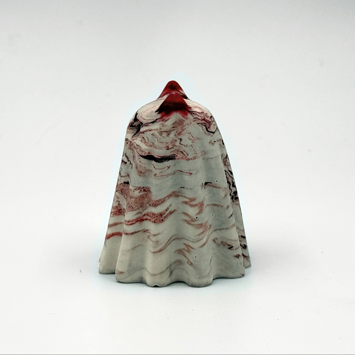 A small grey and white marbled ghost cat figurine with red ripples throughout. Handmade by The Nordic Ghost Merchants. Side view
