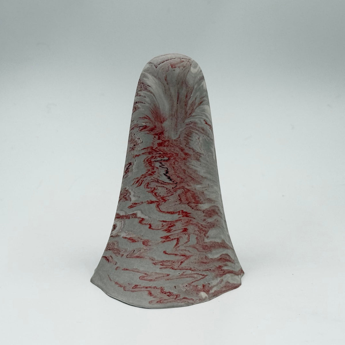 A grey and white marbled ghost figurine handmade by The Nordic Ghost Merchants. The ghost has dark red ripples throughout. Rear view on a grey studio background.