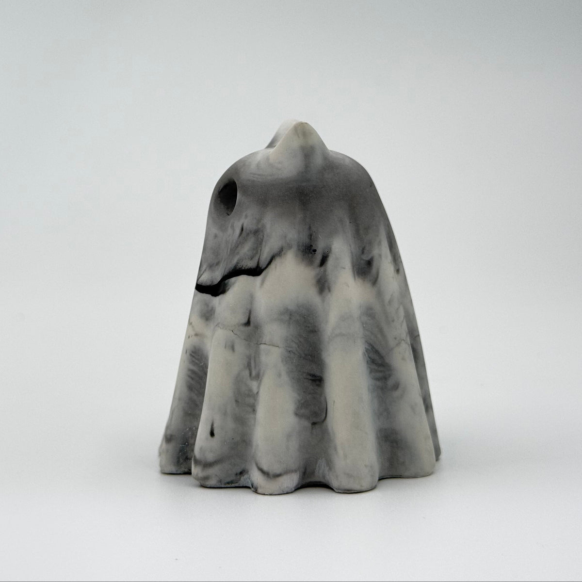 A small grey and white ghost cat figurine, inspired by foggy mornings and made by The Nordic Ghost Merchants. Side view