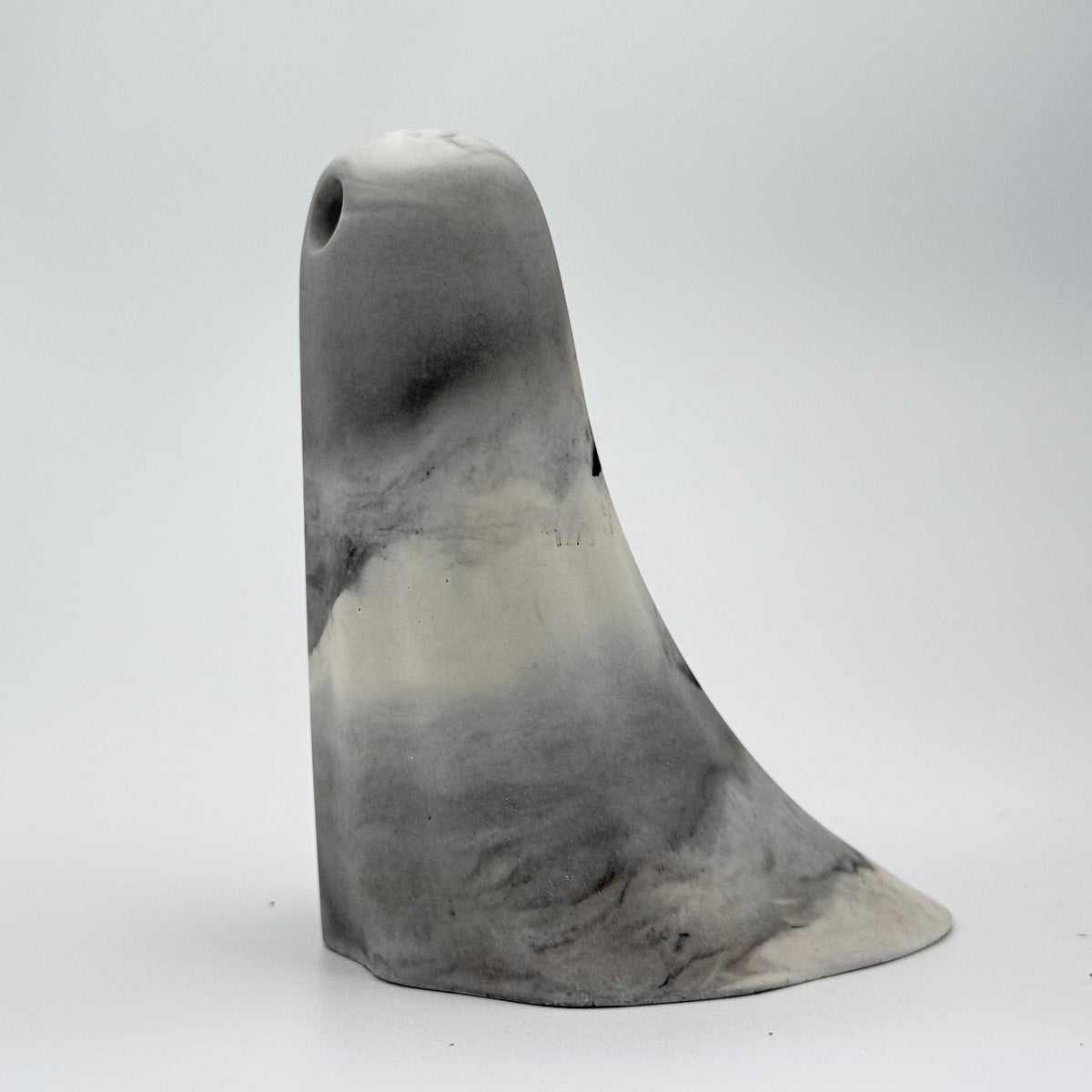 A handmade ghost figurine in swirling shades of grey and white, reminiscent of fog, made by The Nordic Ghost Merchants. Side view