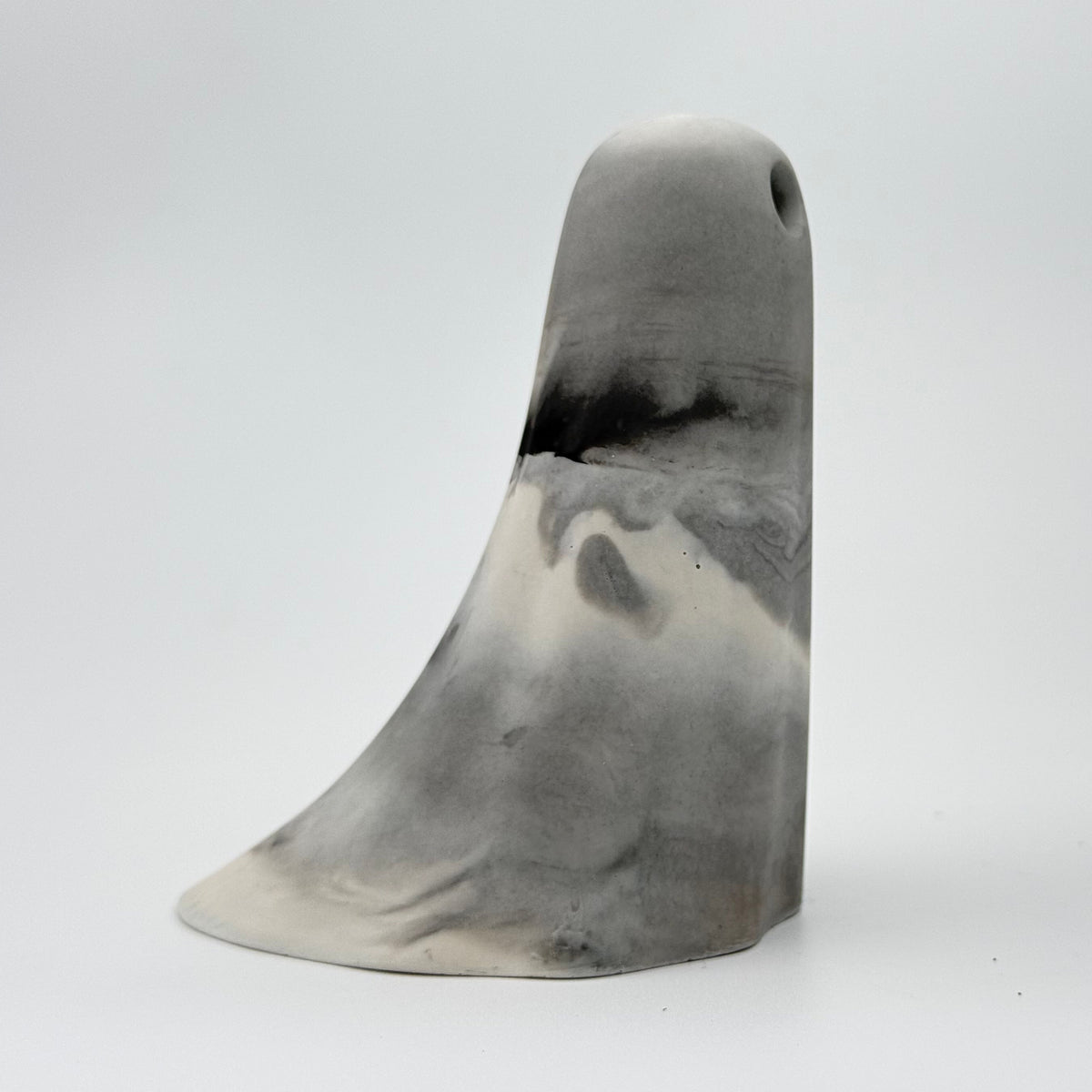 A handmade ghost figurine in swirling shades of grey and white, reminiscent of fog, made by The Nordic Ghost Merchants. Side view
