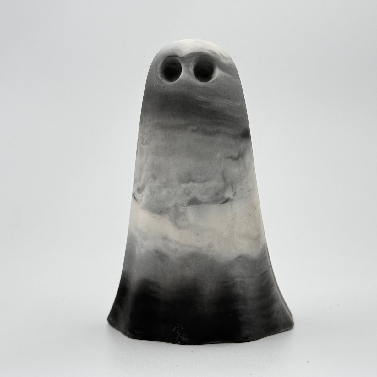 A grey and white marbled handmade ghost figurine by The Nordic Ghost Merchants. Its colouring resembles fog. Front view
