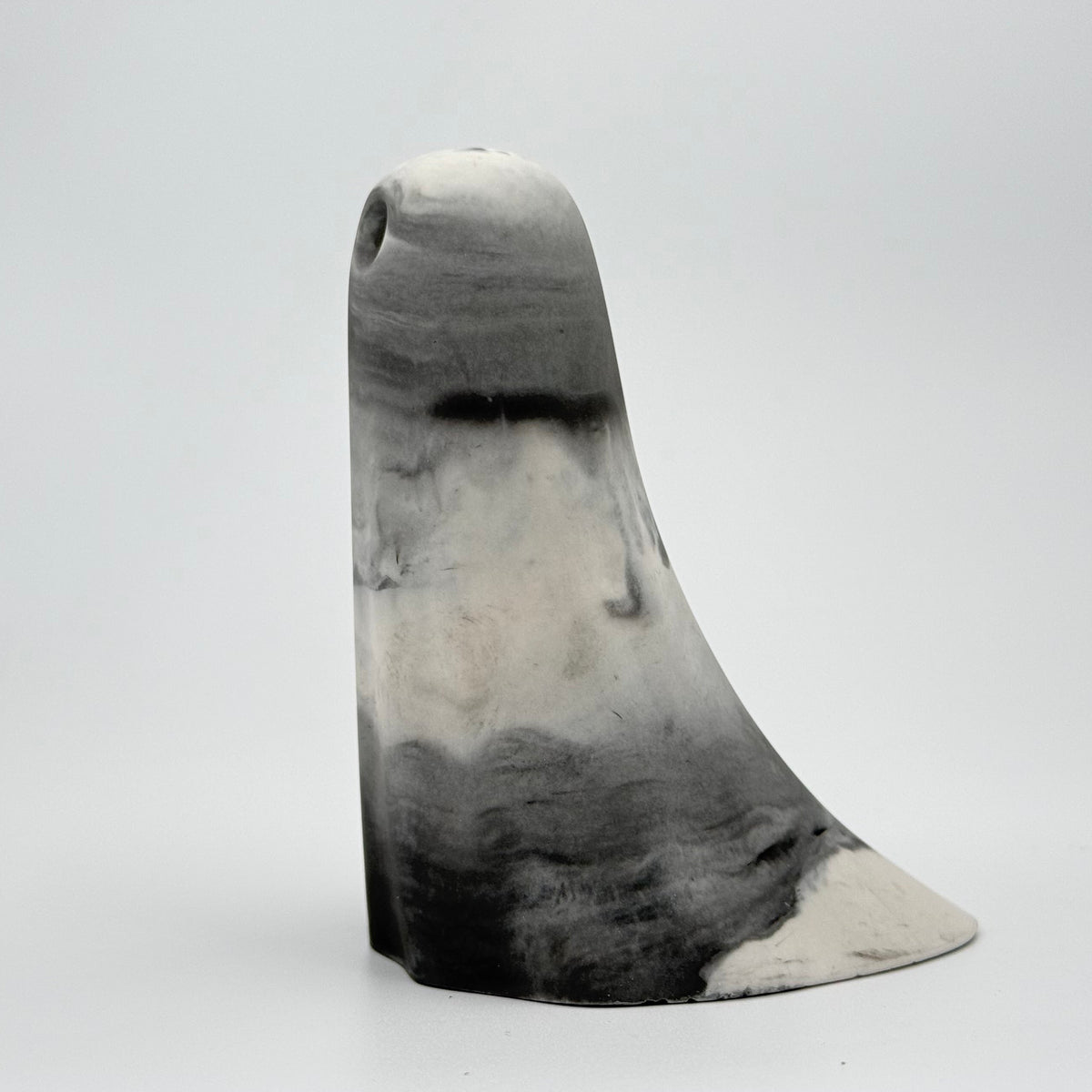 A grey and white marbled handmade ghost figurine by The Nordic Ghost Merchants. Its colouring resembles fog. Side view